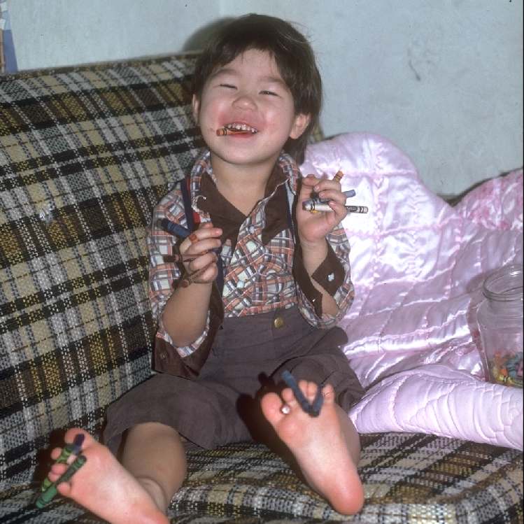Simon holding 14 crayons in Eugene in 1980